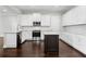 Bright kitchen features white cabinets, stainless steel appliances, a dark island, and beautiful wood floors at 4606 W Fig St # 4, Tampa, FL 33609