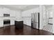 An open-concept kitchen with stainless steel appliances, white cabinets, and a dark island is featured at 4606 W Fig St # 4, Tampa, FL 33609
