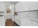 White kitchen features white cabinets with quartz counters with access to the nearby powder room and butler's pantry at 4606 W Fig St # 4, Tampa, FL 33609