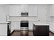 Bright kitchen features white cabinets, stainless steel appliances, a dark island, and beautiful wood floors at 4606 W Fig St # 4, Tampa, FL 33609