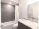 Modern bathroom with gray tile, white vanity, and updated fixtures at 3431 Sheephead Dr, Hernando Beach, FL 34607