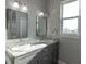Modern bathroom with gray vanity, double sinks, and marble countertops at 3431 Sheephead Dr, Hernando Beach, FL 34607