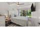 King bedroom with large windows, ceiling fan and views of the lush landscape at 5030 N Beach Rd # 2, Englewood, FL 34223