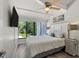 Main bedroom with large windows, ceiling fan, and striped bedding at 5030 N Beach Rd # 2, Englewood, FL 34223