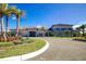 Community clubhouse with palm trees and driveway at 32588 Tree Of Life Ave, Wesley Chapel, FL 33543