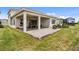 Covered patio with pavers, seating area, grill, and grassy yard at 32588 Tree Of Life Ave, Wesley Chapel, FL 33543