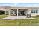 Covered patio with pavers, seating area, grill, and grassy yard at 32588 Tree Of Life Ave, Wesley Chapel, FL 33543