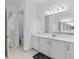 Bright bathroom boasts double vanity, large mirror, and shower at 32588 Tree Of Life Ave, Wesley Chapel, FL 33543