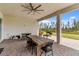 Covered patio with wooden dining table, chairs, and grill at 32588 Tree Of Life Ave, Wesley Chapel, FL 33543