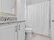 Clean bathroom with granite countertop, white cabinets, and shower at 32588 Tree Of Life Ave, Wesley Chapel, FL 33543