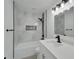 Modern bathroom with grey marble tile, bathtub, and quartz countertop at 5224 Mango Fruit St, Seffner, FL 33584
