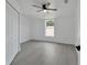 Bright bedroom with wood-look floors, double doors, and ceiling fan at 5224 Mango Fruit St, Seffner, FL 33584
