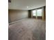 Large bedroom with neutral tones and carpet, highlighted by natural light from two large windows at 462 Spotted Slipper Pl, Ruskin, FL 33570