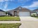 Single-story home with two-car garage and landscaping at 36158 Welsh Glade Rd, Dade City, FL 33525