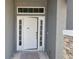 White front door with sidelights and stone accents at 36158 Welsh Glade Rd, Dade City, FL 33525