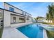 Spacious backyard featuring a modern home exterior, covered patio, pool, and spa, perfect for outdoor enjoyment at 2106 S Cortez Ave, Tampa, FL 33629