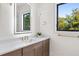 Bright bathroom with dual windows, sleek vanity, gold fixtures, and a modern illuminated mirror at 2106 S Cortez Ave, Tampa, FL 33629
