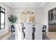 Modern dining room with light wood floors, large windows, and gold chandelier for an elegant dining experience at 2106 S Cortez Ave, Tampa, FL 33629