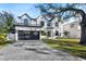 Stunning new construction home featuring a brick driveway, lush lawn, and a dark colored, three-car garage at 2106 S Cortez Ave, Tampa, FL 33629