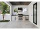 Well-equipped outdoor kitchen with a stainless steel grill, refrigerator, sink, and stone accents at 2106 S Cortez Ave, Tampa, FL 33629
