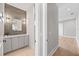 Stylish powder room featuring a modern vanity, decorative mirror, and wood-look tile accent wall at 2106 S Cortez Ave, Tampa, FL 33629