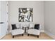 Cozy sitting area with neutral chairs, accent pillows, a modern art piece, and wood floors at 2106 S Cortez Ave, Tampa, FL 33629