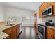 Modern kitchen featuring stainless steel appliances and dark wood floors at 3554 Deer Run S, Palm Harbor, FL 34684