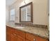 Bathroom boasts granite countertop, wood cabinets and a large mirror at 3554 Deer Run S, Palm Harbor, FL 34684