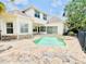 Spacious backyard with a pool and spa, stone patio, and screened lanai at 1227 Toscano Dr, Trinity, FL 34655