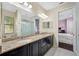 A spacious bathroom features a double vanity with a granite countertop and a large mirror at 1227 Toscano Dr, Trinity, FL 34655