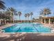 Large community pool featuring palm trees, lounge chairs, and brick pavers at 1227 Toscano Dr, Trinity, FL 34655