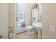 Small bathroom with pedestal sink, toilet and door to backyard at 1227 Toscano Dr, Trinity, FL 34655