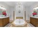 Elegant bathroom with a large soaking tub, dual vanities, and chandelier at 13231 Snowy Plover Ave, Weeki Wachee, FL 34614