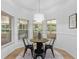 Bright breakfast nook with a round table and three chairs, surrounded by windows at 13231 Snowy Plover Ave, Weeki Wachee, FL 34614