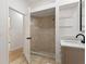 Bathroom with a shower, vanity with a quartz countertop, and glass shelving at 13231 Snowy Plover Ave, Weeki Wachee, FL 34614