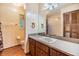 Bathroom featuring wood cabinets, large mirror, and access to shower area at 6605 Pemberton Sage Ct, Seffner, FL 33584