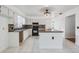 Well-lit kitchen with an island, stone backsplash, and modern appliances at 6605 Pemberton Sage Ct, Seffner, FL 33584