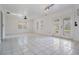 Bright living room with white tile flooring, multiple windows, a skylight, and glass paneled doors at 6605 Pemberton Sage Ct, Seffner, FL 33584