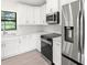 Modern kitchen with stainless steel appliances and white cabinets at 9171 Prospect Ave, Englewood, FL 34224