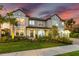 Elegant two-story home with manicured landscaping and a welcoming front entrance at sunset at 7135 Graybrook Dr, Wesley Chapel, FL 33545