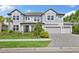 Charming two-story home with a three-car garage, manicured lawn, and lovely landscaping at 7135 Graybrook Dr, Wesley Chapel, FL 33545