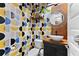 Stylish bathroom with a modern vanity, geometric wallpaper, and a round mirror at 7135 Graybrook Dr, Wesley Chapel, FL 33545