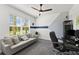 Home office with a gray sofa, desk, and large window at 7135 Graybrook Dr, Wesley Chapel, FL 33545