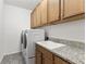 Laundry room with washer, dryer, granite countertop, and cabinets at 7135 Graybrook Dr, Wesley Chapel, FL 33545