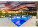 Night view of a screened-in pool and spa, perfect for evening relaxation at 7135 Graybrook Dr, Wesley Chapel, FL 33545