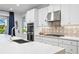 Modern kitchen with white cabinets, stainless steel appliances, and patterned backsplash at 7135 Graybrook Dr, Wesley Chapel, FL 33545