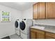 Bright laundry room, washer, dryer, and built-in cabinets at 7135 Graybrook Dr, Wesley Chapel, FL 33545