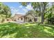 Spacious backyard with green lawn, patio, screened pool, and mature trees at 3501 Country Creek Ln, Valrico, FL 33596