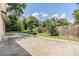 Fenced backyard with trees and grass surrounding a large concrete patio at 3501 Country Creek Ln, Valrico, FL 33596