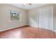 Bedroom features hardwood floors, a window with blinds, and a closet with bi-fold doors at 3501 Country Creek Ln, Valrico, FL 33596